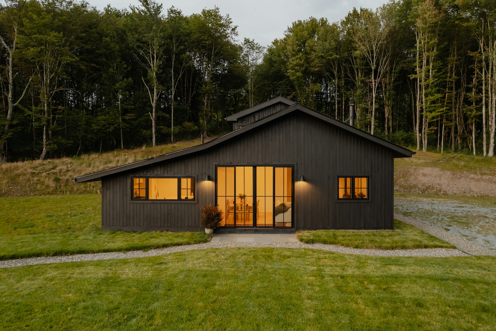 Maison en bardage noir dans la prairie
